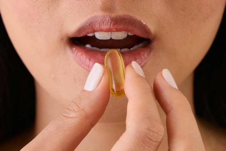Woman putting supplements into her mouth